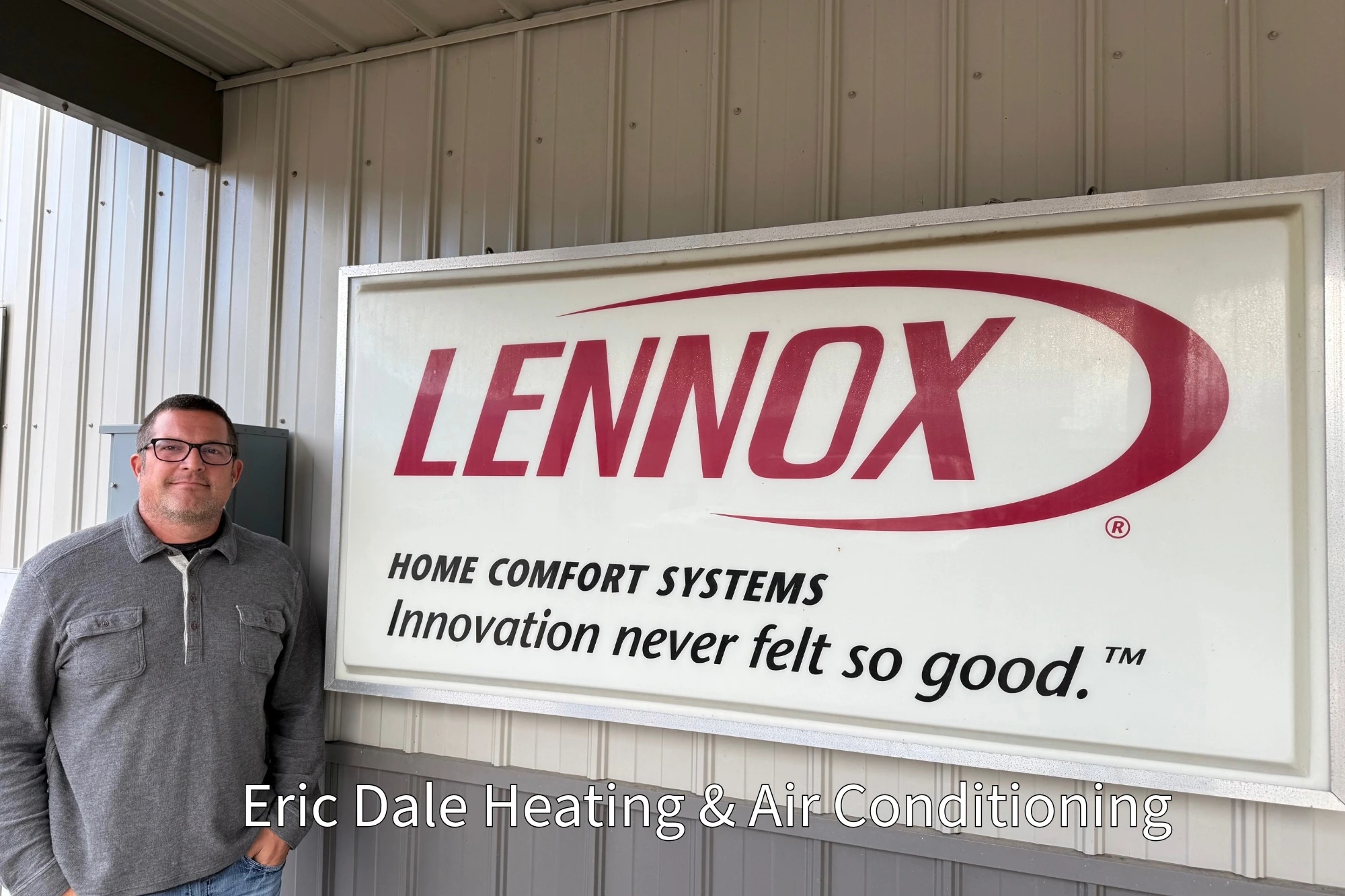 Eric Dale Heating and cooling owner standing beside a lennox Sign